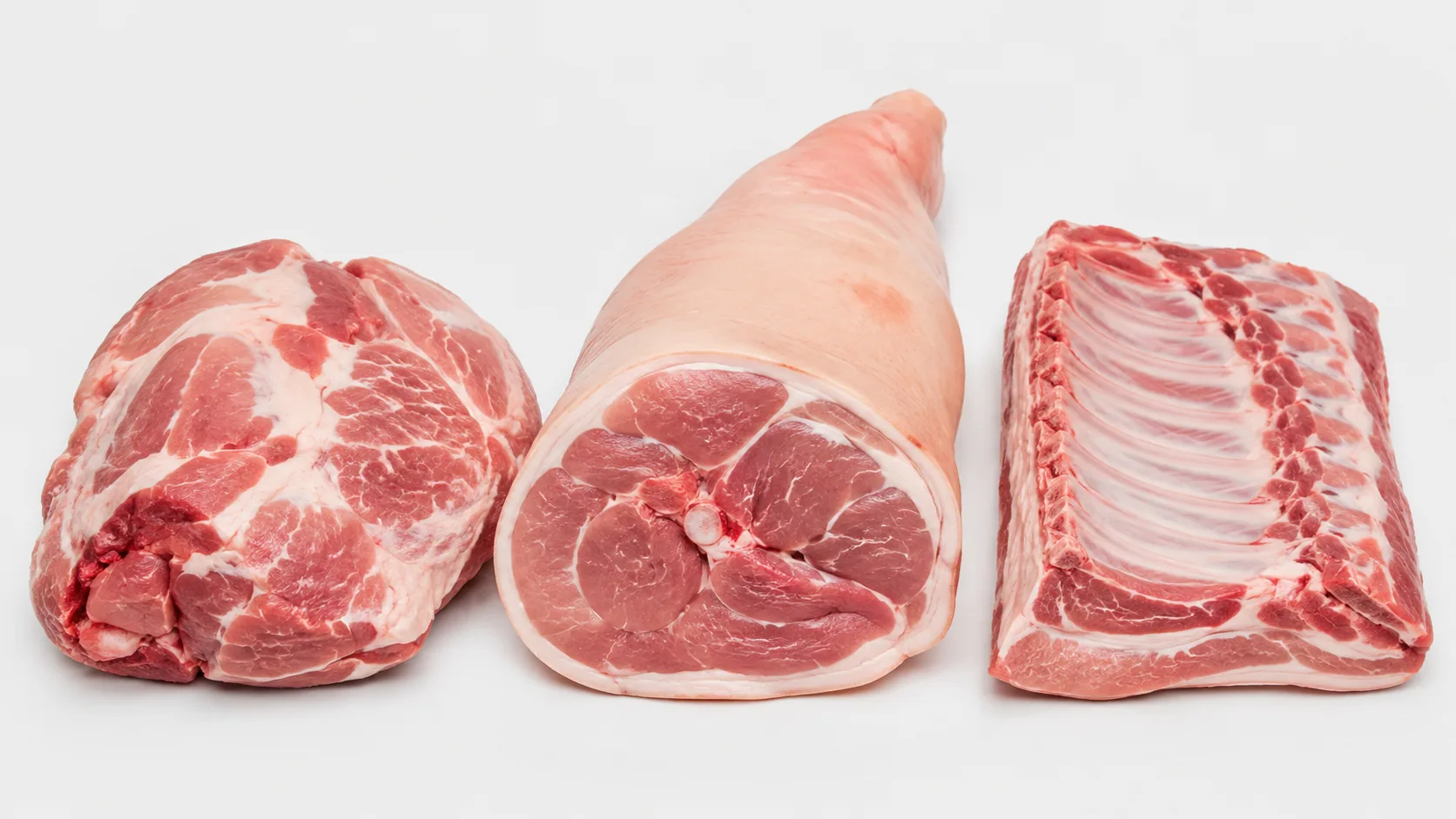 Cortes de cerdo preparados sobre una superficie blanca